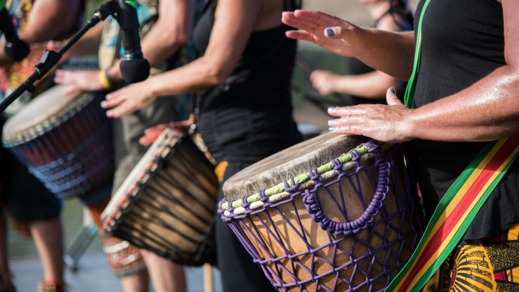 Hands playing djembe drums