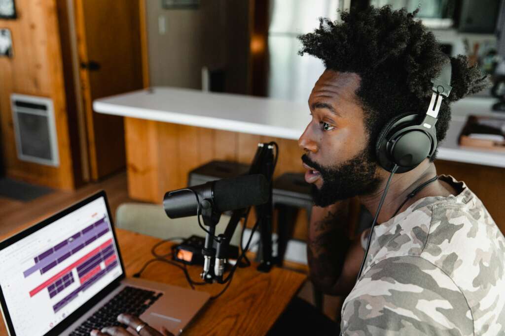 Music producer wearing headphones at a home studio desk