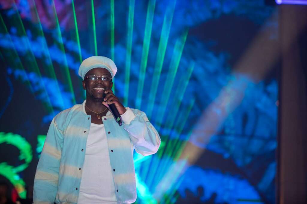 Singer performing on stage under blue and green lights